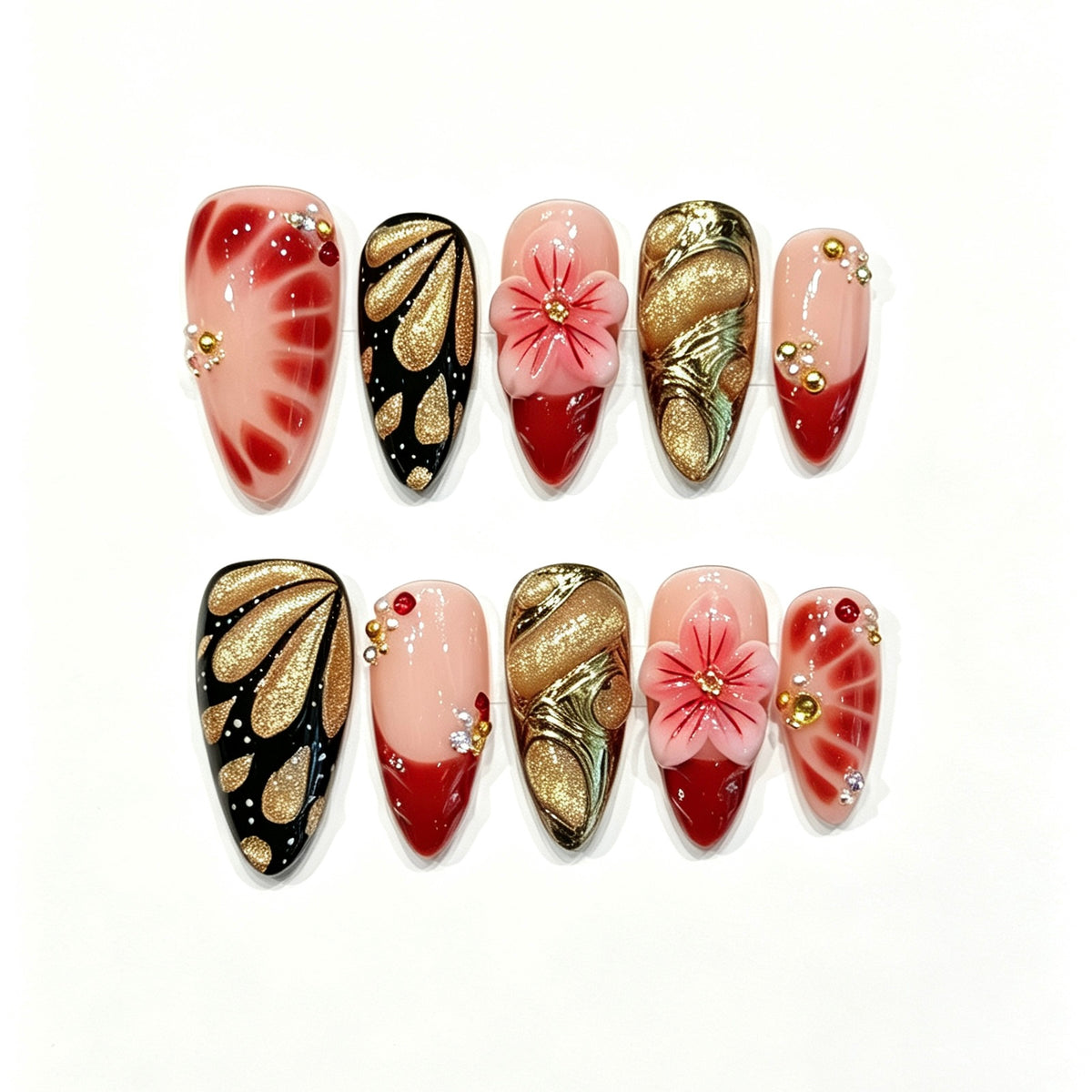 Red and black press-on nails with gold fan accents and a sculpted red poinsettia-style flower