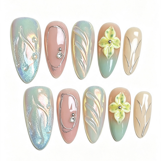 A set of ten false press-on nails arranged in two rows on a plain white background. The nails feature pastel designs including iridescent blue-green, dusty pink, mint green, beige, and light yellow floral accents with metallic gold leaf patterns.