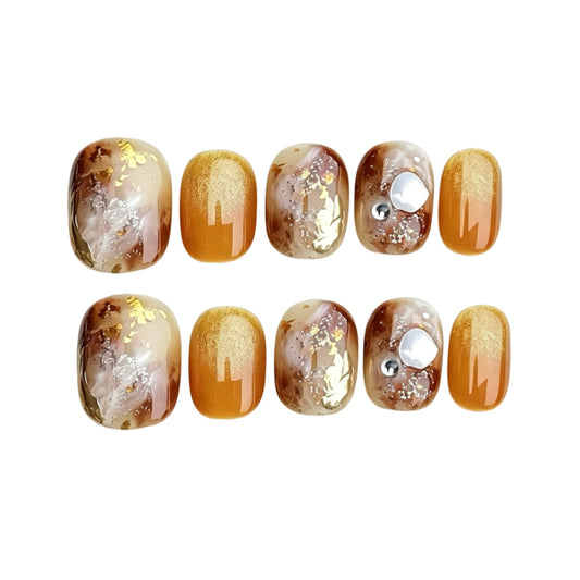 Amber and cream marble press-on nails with gold foil and pearl details